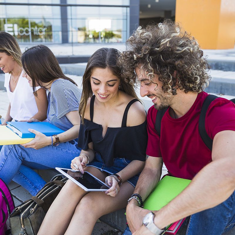 euroaula-students-using-tablet-near-friends